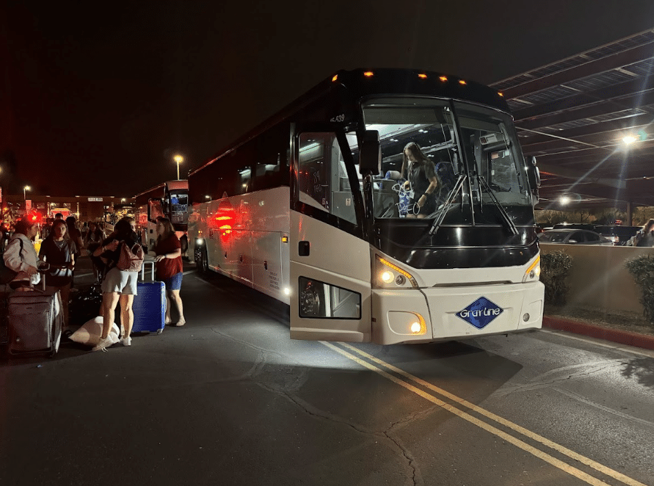 Gray Line charter bus at night with passengers disembarking, possibly after arriving at a food and wine festival in Scottsdale.