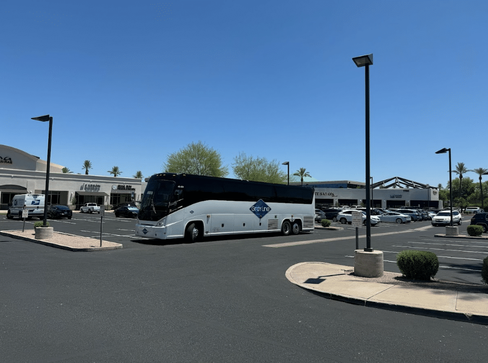 Gray Line charter bus parked in a parking lot, possibly waiting for passengers attending the food and wine festival in Scottsdale.